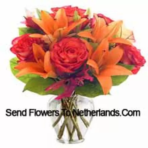 Lys orange et roses orange avec des garnitures saisonnières arrangés magnifiquement dans un vase en verre